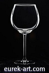 Eine Serviette in ein Weinglas falten
